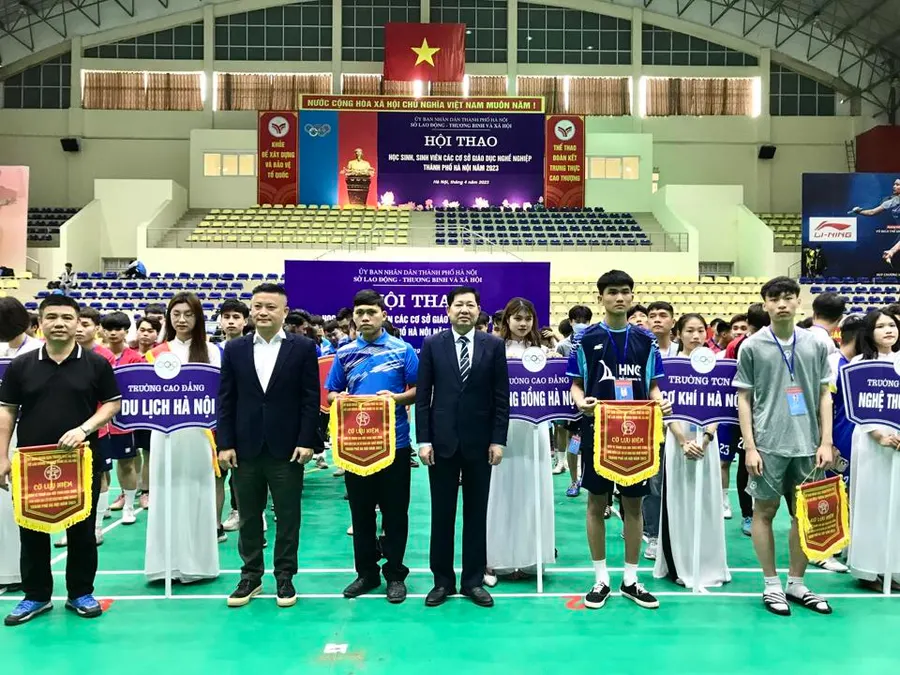 Phó Vụ trưởng Vụ Công tác Học sinh, sinh viên, Tổng cục giáo dục nghề nghiệp Phạm Ngọc Thắng và Phó Giám đốc Sở LĐTB&XH Hà Nội Hoàng Thành Thái trao cờ lưu niệm cho các đơn vị tham gia Hội thao. Ảnh: Trần Oanh.